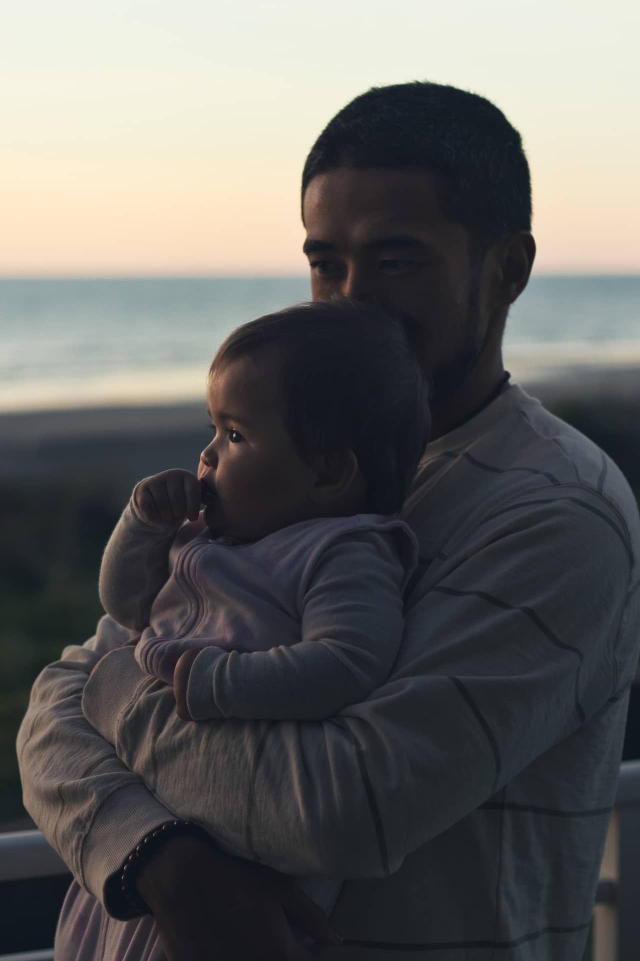 Photo of a father holding his little baby daughter.